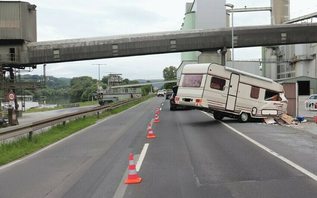 Ein völlig zerstörter Wohnwagen hängt nach einem Unfall an einer Mauer Ein völlig zerstörter Wohnwagen hängt nach einem Unfall an einer Mauer
